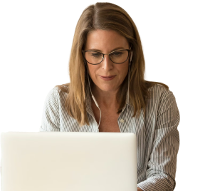 a woman in glasses sat down looking at her computer